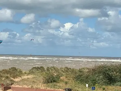 two people are flying kites on the beach at Beach Lookout - SEA VIEWS in Lytham St Annes