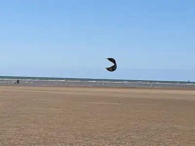 a person is flying a kite on the beach at Beach Lookout - SEA VIEWS in Lytham St Annes