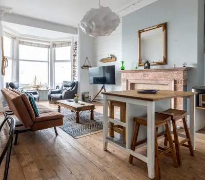 a living room with a table and a fireplace at Beach Lookout - SEA VIEWS in Lytham St Annes