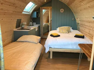 a bedroom with two beds and a sink in it at Orchard Glamping in Catterall