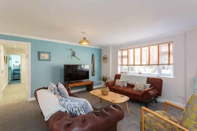 a living room with two couches and a tv at Beach Cottage in Lytham St Annes