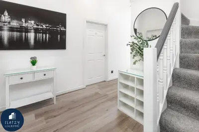 a white staircase in a living room with a mirror at FLATZY - Victoria Street Apartment - Heart of City Centre in Liverpool