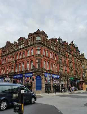 a large red brick building with a blue door at FLATZY - Victoria Street Apartment - Heart of City Centre in Liverpool