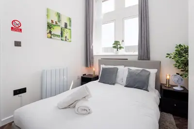 a bedroom with a white bed and a window at FLATZY - Victoria Street Apartment - Heart of City Centre in Liverpool