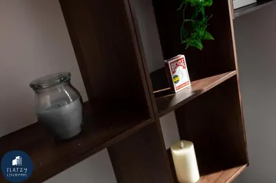 a shelf with a candle and a jar of water at FLATZY - Victoria Street Apartment - Heart of City Centre in Liverpool