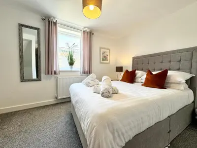 a bedroom with a large white bed with red pillows at The Kipling Inn, 4 - Bed, Sleeps 7, Pets Welcome in Ulverston