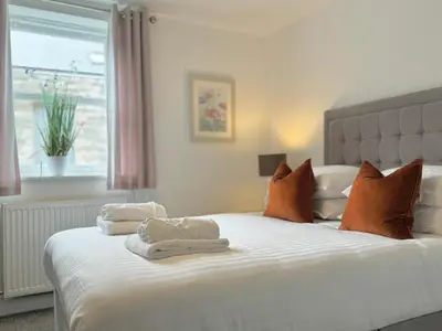 a bedroom with a white bed with towels on it at The Kipling Inn, 4 - Bed, Sleeps 7, Pets Welcome in Ulverston