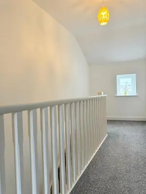 a white room with a staircase and a chandelier at The Kipling Inn, 4 - Bed, Sleeps 7, Pets Welcome in Ulverston