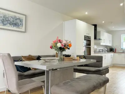 a kitchen and living room with a table with flowers on it at The Kipling Inn, 4 - Bed, Sleeps 7, Pets Welcome in Ulverston