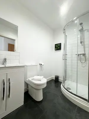 a white bathroom with a toilet and a shower at The Kipling Inn, 4 - Bed, Sleeps 7, Pets Welcome in Ulverston
