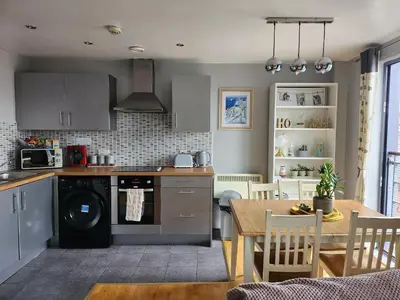 a kitchen with a table and a dining room at Modern central Penthouse - 1 FreeParking in Liverpool