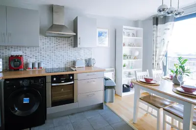 a kitchen with a washing machine and a table at Modern central Penthouse - 1 FreeParking in Liverpool