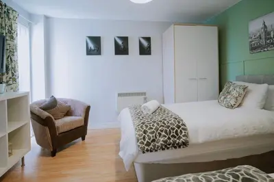a bedroom with a bed and a chair at Modern central Penthouse - 1 FreeParking in Liverpool
