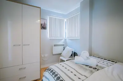 a bedroom with a bed and a white cabinet at Modern central Penthouse - 1 FreeParking in Liverpool