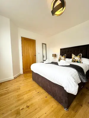 a bedroom with a large bed and a wooden floor at The Birketts Inn, 4 - Bed, Sleeps 8, Pets Welcome in Ulverston