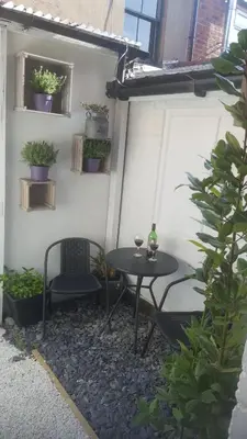 a patio with a table and chairs and plants at Atlantic cottage in Blackpool