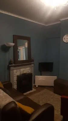 a living room with a fireplace and a mirror at Atlantic cottage in Blackpool