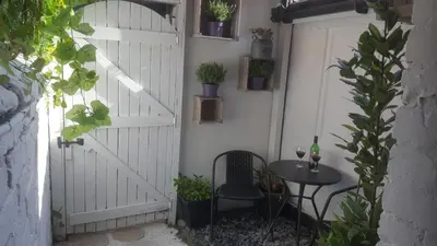 a patio with a white door and a table with a wine glass at Atlantic cottage in Blackpool