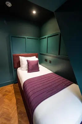 a bedroom with a bed with a purple and white blanket at Duke Street Boutique Hotel in Liverpool