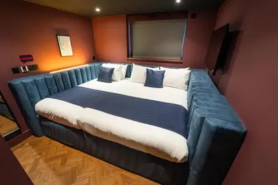 a large bed in a room with a blue couch at Duke Street Boutique Hotel in Liverpool