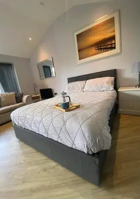 a bedroom with a bed with a tray on it at Dean Clough Lodge - Contemporary self contained studio in Wilpshire