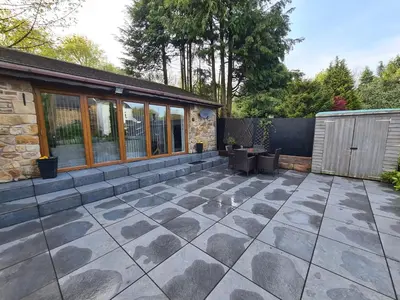 a patio with a stone floor and a building at Dean Clough Lodge - Contemporary self contained studio in Wilpshire