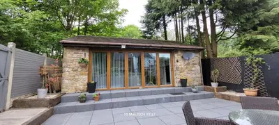 a small stone building with a table and chairs at Dean Clough Lodge - Contemporary self contained studio in Wilpshire