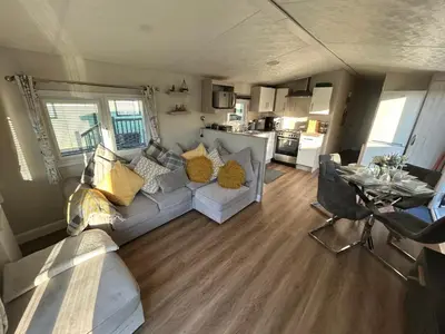 a living room with a couch and a kitchen at 12 Borwick Lakes- Newly Refurbished in Carnforth