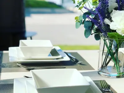 a table with plates and a vase of flowers on it at 12 Borwick Lakes- Newly Refurbished in Carnforth