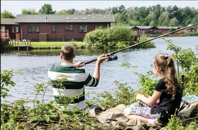 a man and a woman fishing on a lake at 12 Borwick Lakes- Newly Refurbished in Carnforth