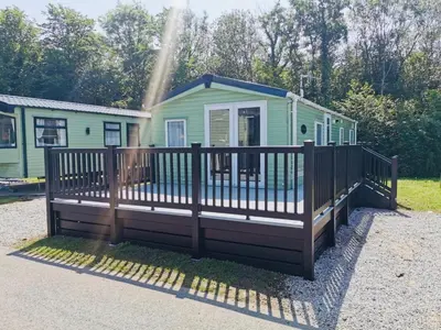 a tiny house with a fence in front of it at 12 Borwick Lakes- Newly Refurbished in Carnforth