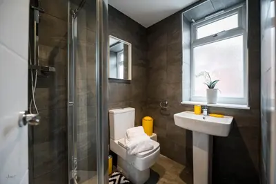 a bathroom with a toilet and a sink and a window at Charles Alexander Short Stay - Windmill House Apartments in Lytham St Annes