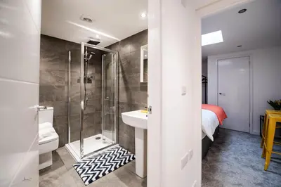 a bathroom with a shower and a toilet and a sink at Charles Alexander Short Stay - Windmill House Apartments in Lytham St Annes