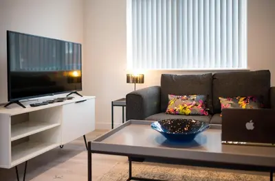 a living room with a couch and a table at Charles Alexander Short Stay - Windmill House Apartments in Lytham St Annes