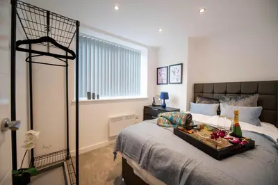 a bedroom with a bed with a tray of food on it at Charles Alexander Short Stay - Windmill House Apartments in Lytham St Annes