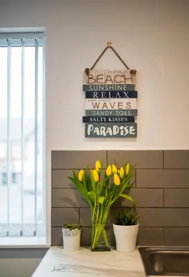 a vase of yellow tulips on a counter in a kitchen at Charles Alexander Short Stay - Windmill House Apartments in Lytham St Annes
