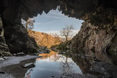 a view of a river through a cave at Low Greenlands Holiday Park - Luxury House & Luxury Glamping Pods in Lancaster