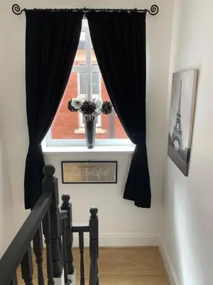 a stairway with a window with black curtains at Alandene in Blackpool