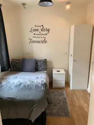 a bedroom with a bed with a sign on the wall at Alandene in Blackpool