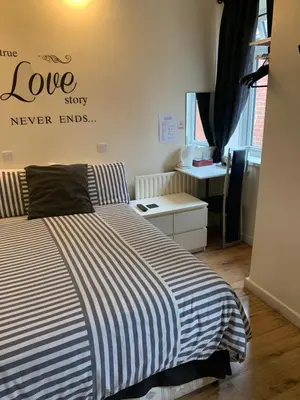 a bedroom with a bed and a sign that reads love story never ends at Alandene in Blackpool