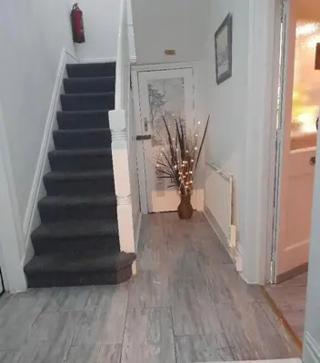 a staircase in a house with a vase on the floor at Mr sandman’s hotel in Blackpool