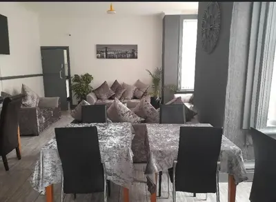 a living room with a table and a couch at Mr sandman’s hotel in Blackpool