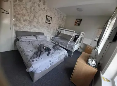 a bedroom with two beds and a nightstand at Mr sandman’s hotel in Blackpool