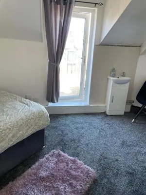a bedroom with a bed and a window at Mr sandman’s hotel in Blackpool