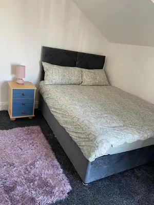 a bedroom with a bed with a nightstand and a bed sidx sidx at Mr sandman’s hotel in Blackpool