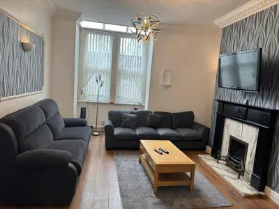 a living room with two couches and a fireplace at Norwyn Court Holiday Apartments in Blackpool