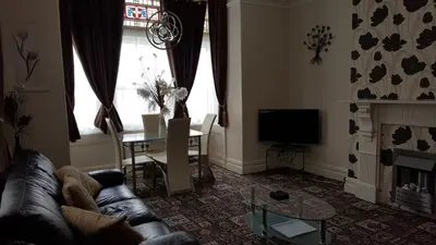 a living room with a couch and a television at Norwyn Court Holiday Apartments in Blackpool