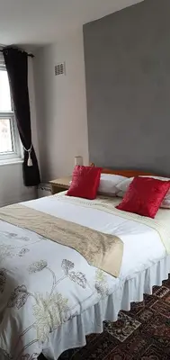 a bedroom with two beds with red pillows on them at Norwyn Court Holiday Apartments in Blackpool