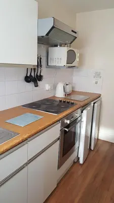 a kitchen with a stove and a microwave at Norwyn Court Holiday Apartments in Blackpool
