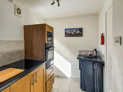 a kitchen with wooden cabinets and a black counter top at Sunnyside Cottage in Crossens